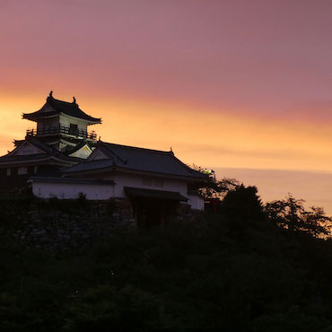 夕焼けの中の浜松城天守閣の様子の画像