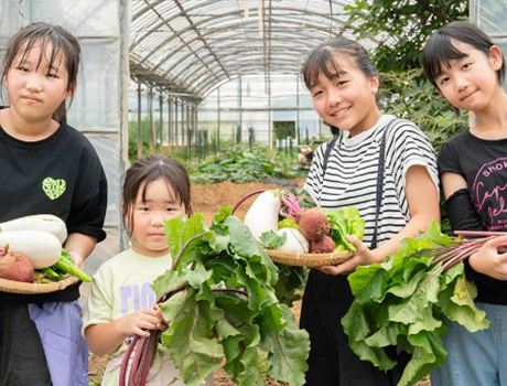 子どもたちが野菜を抱えている画像